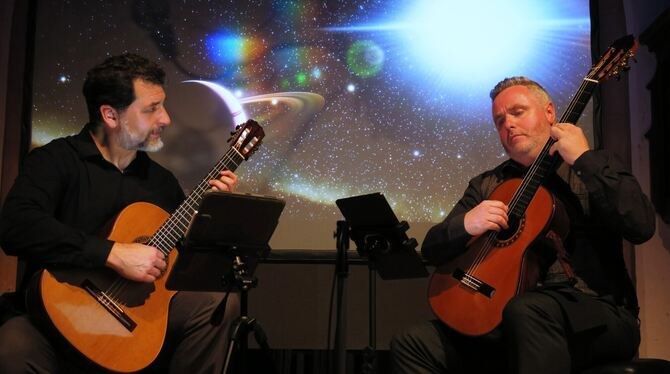 Cochran & McAllister performing in front of projected images of space